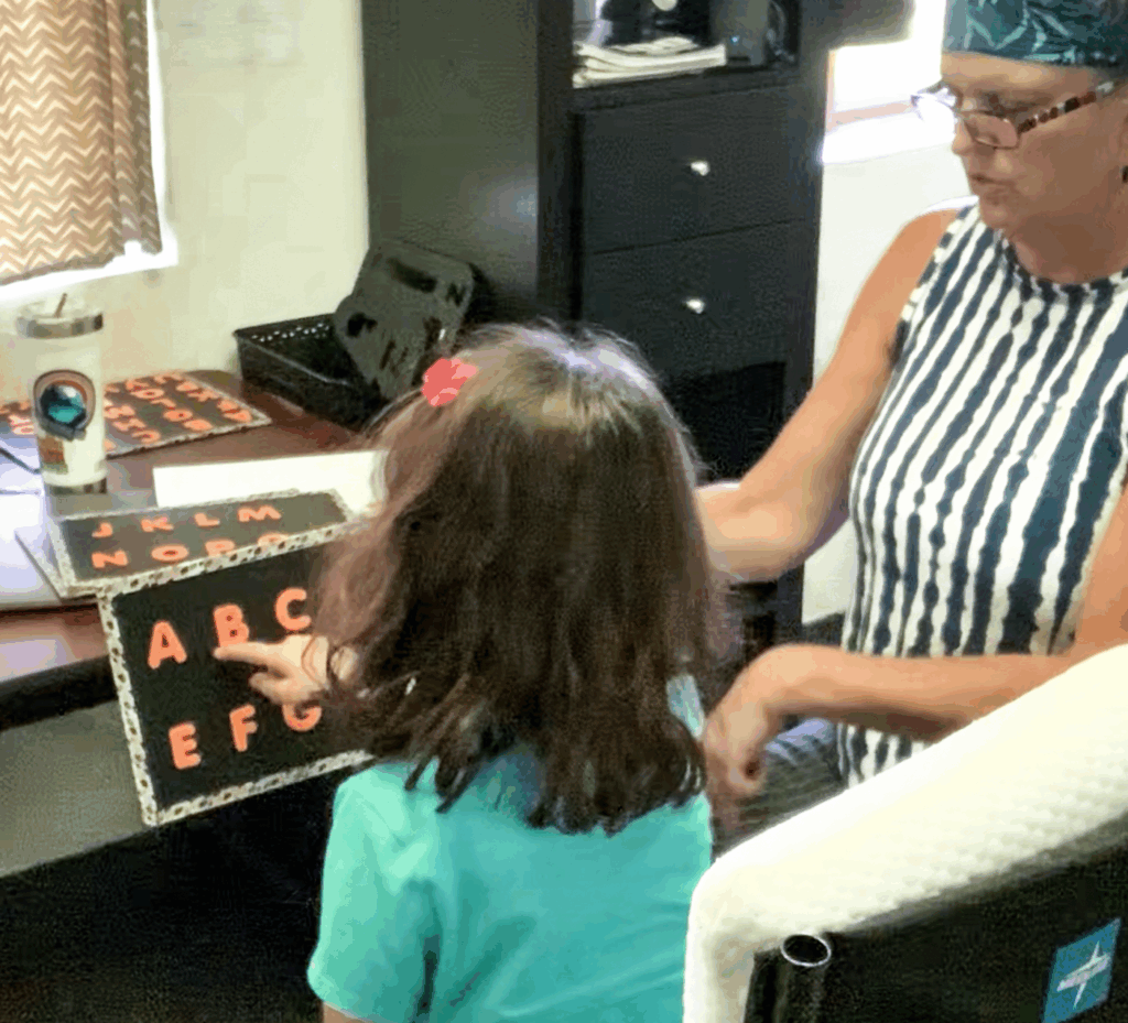 Beth Susag using a point to spell technique with a little girl